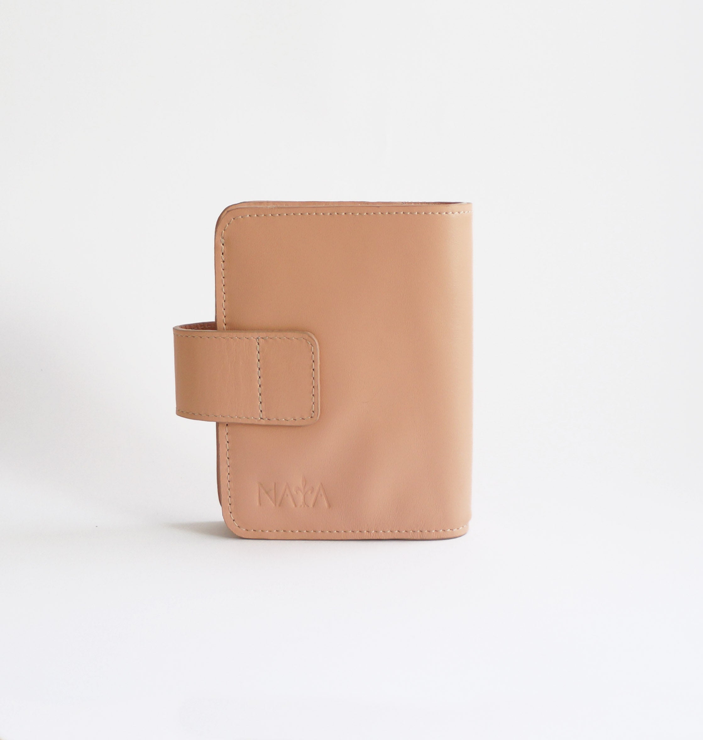Back view of blush pink Passport TN leather cover with embossed Naya logo and secure snap strap